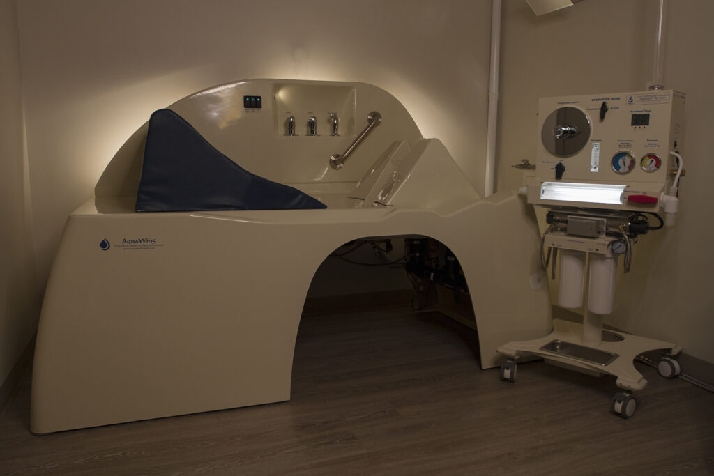 AquaWing OPEN colon hydrotherapy treatment table and control unit in clinical setting.
