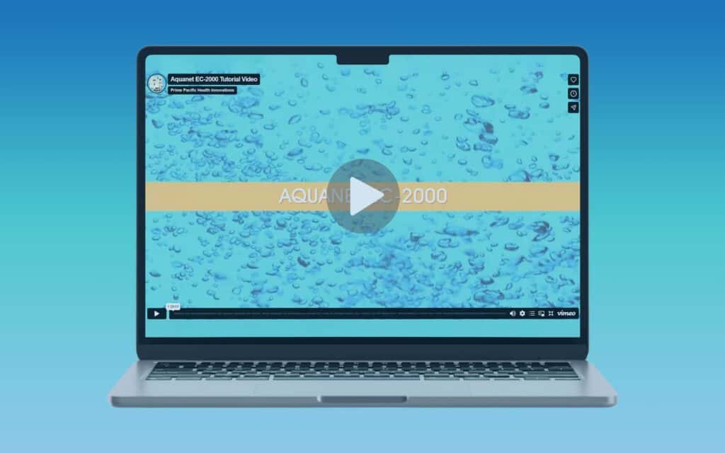 Laptop displaying Aquanet EC-2000 tutorial video with a blue water-themed background. Play button in the center.