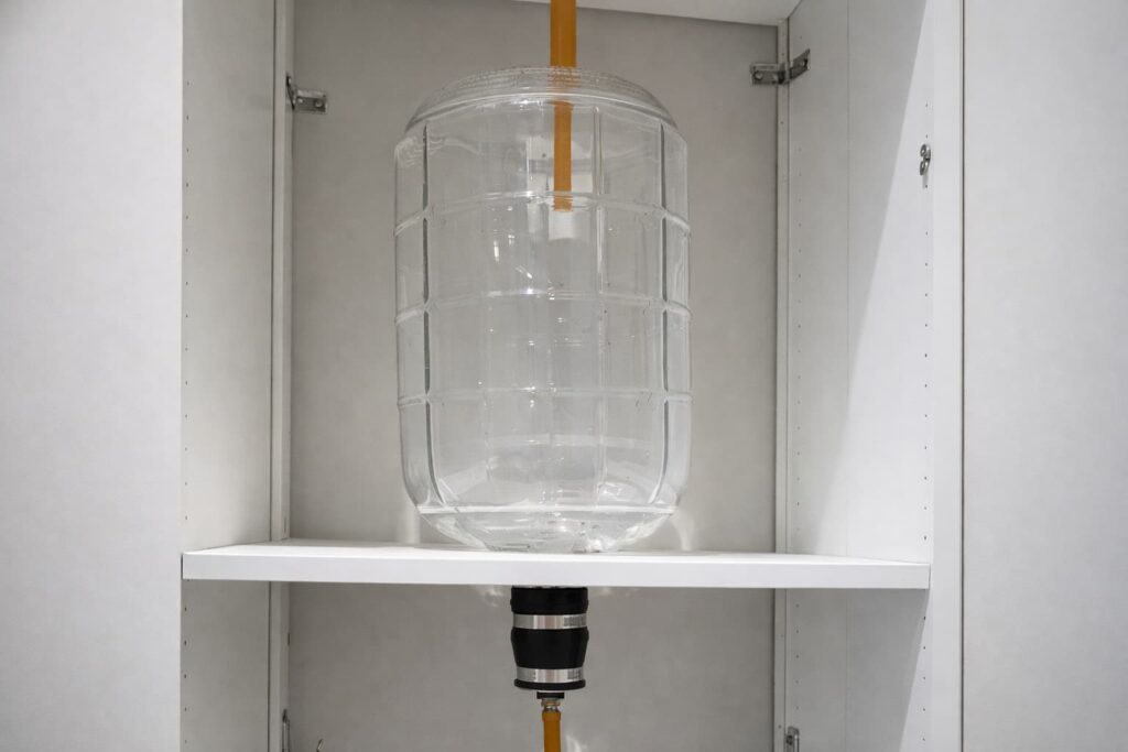 Old Gravity System with a yellow tube, positioned on a white shelf inside a cabinet.